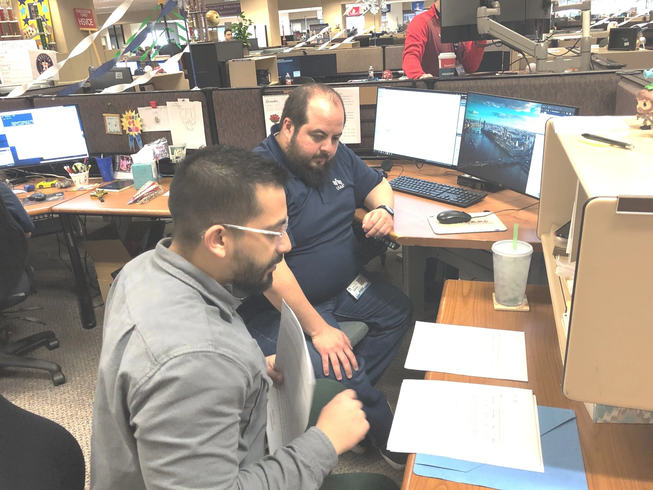 A feedback session at an MSR’s desk, printed screens on the desk