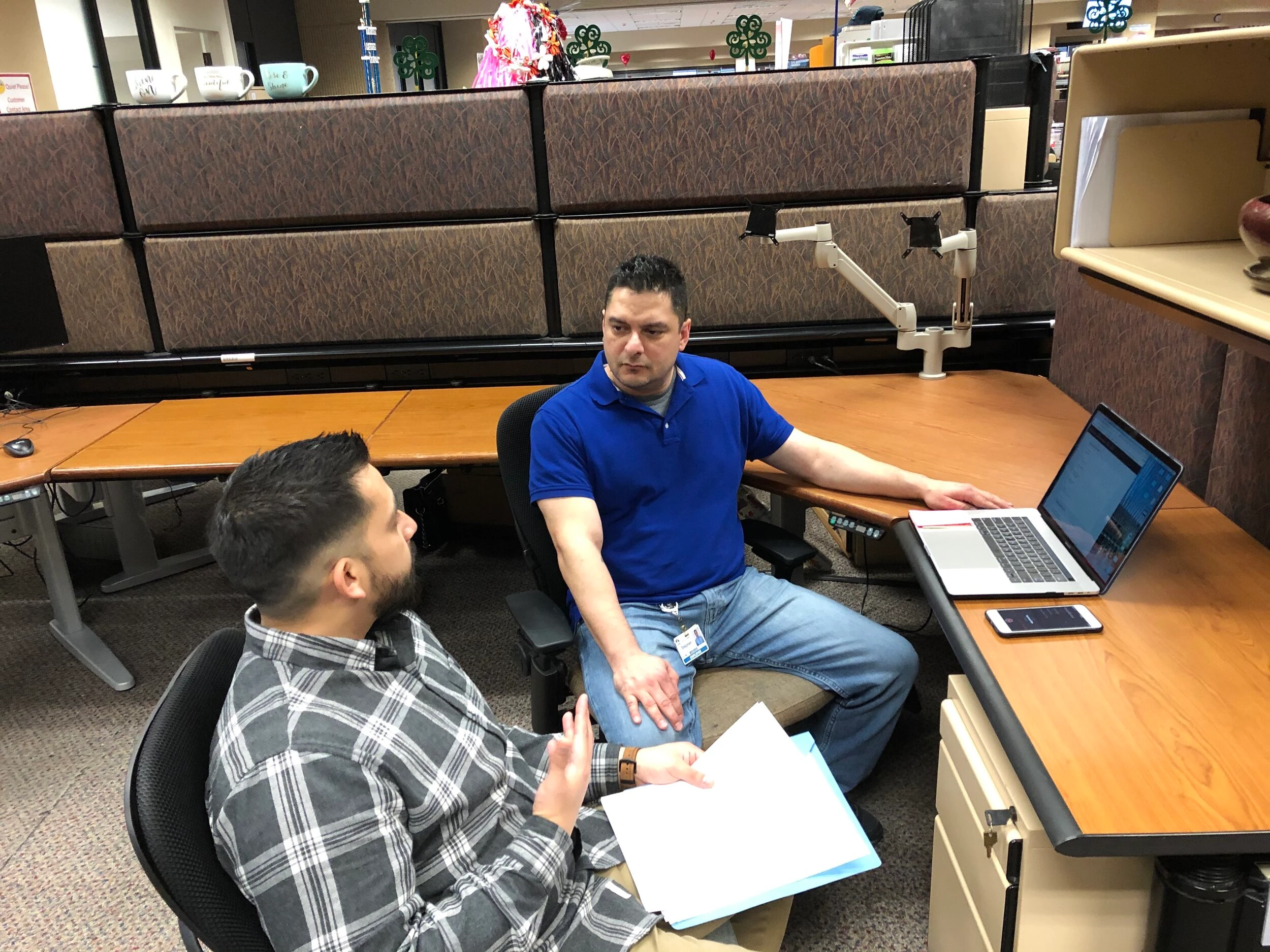 A feedback session: printed screens and a laptop at an MSR’s desk